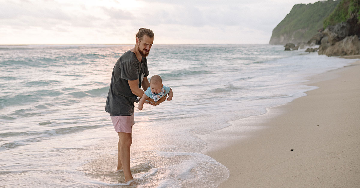 dad on beach vacation with baby