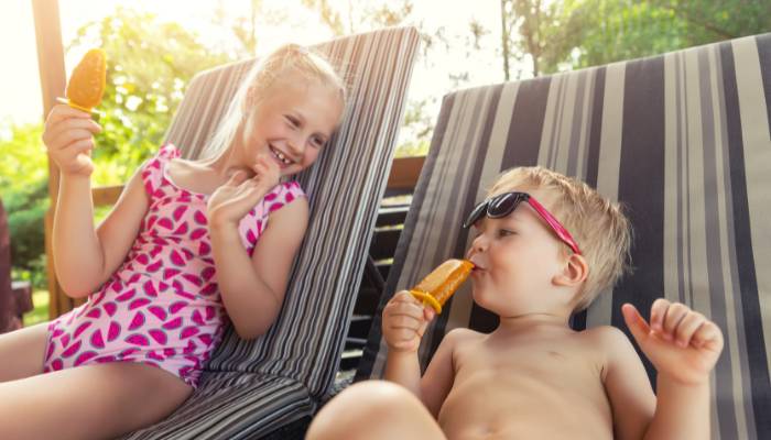 kids with popsicles by pool