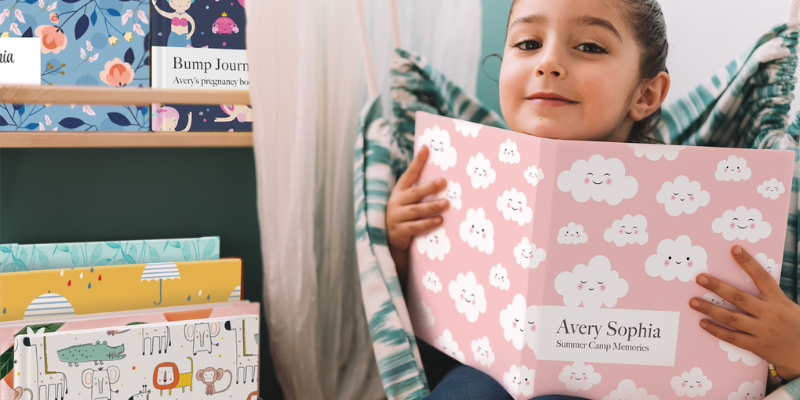 young girl looking at baby book